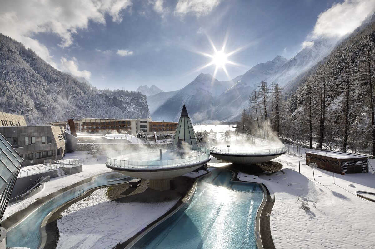 The Aqua Dome in Längenfeld, its pools steaming in the snow below a mountain range in winter sun