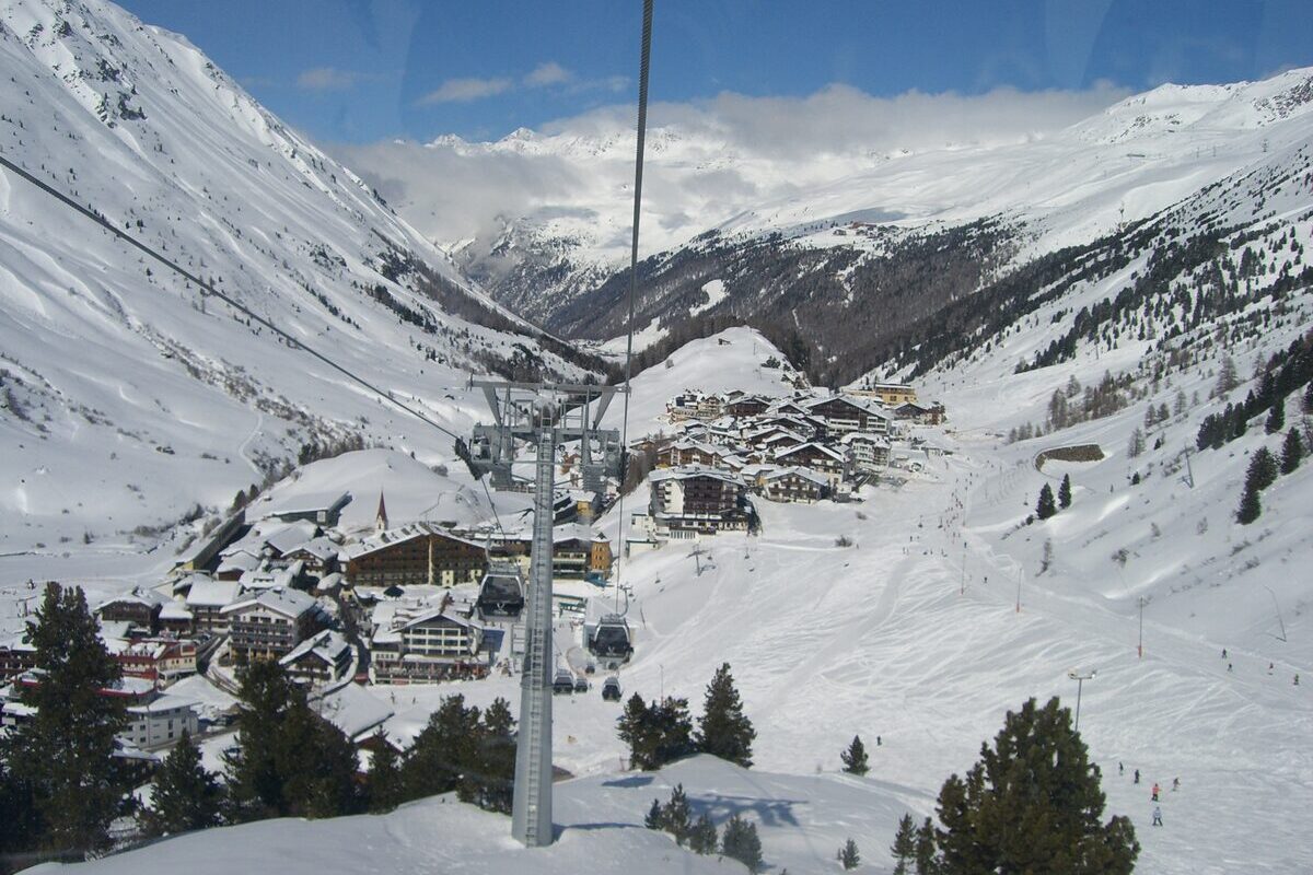 Obergurgl in the snow, seen from a gondola: hotels and a church spire below the ski slopes