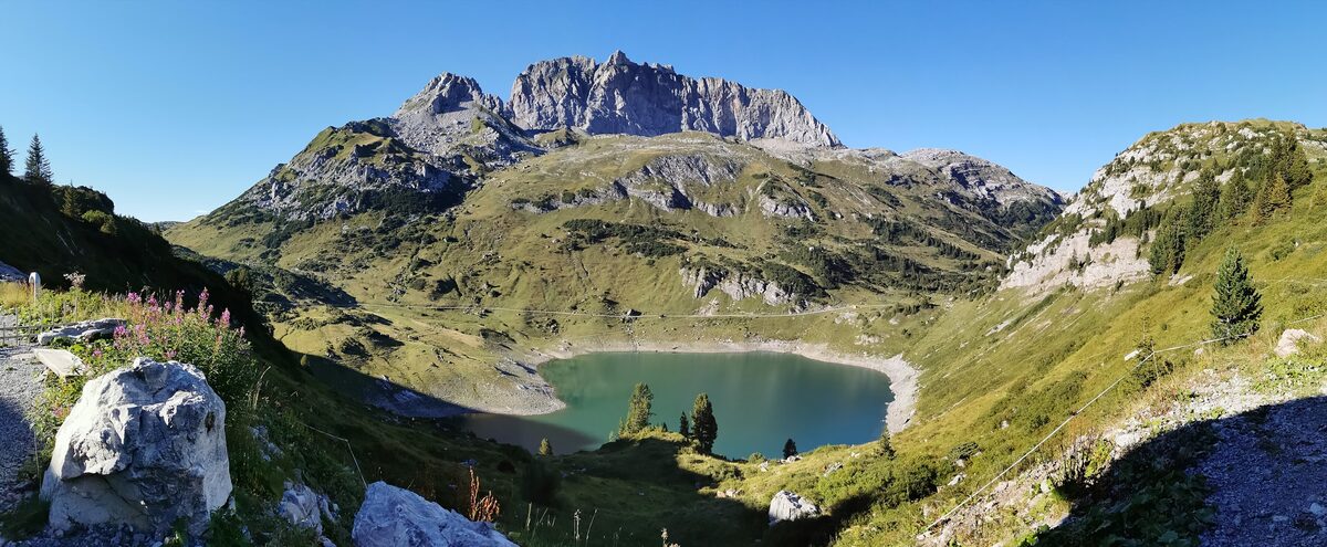 The Formarinsee in summer, a green mountain lake in a bowl of grass and rock