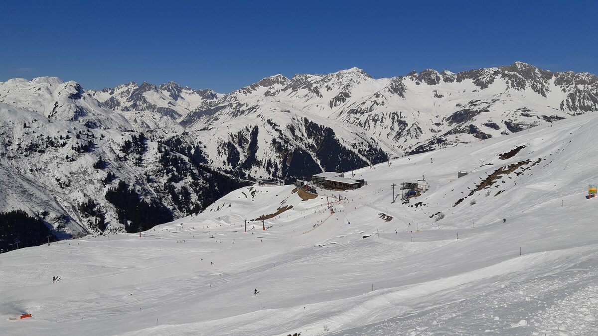 The mountain station and restaurant of the Rendlbahn in snow, with snowy slopes and peaks behind