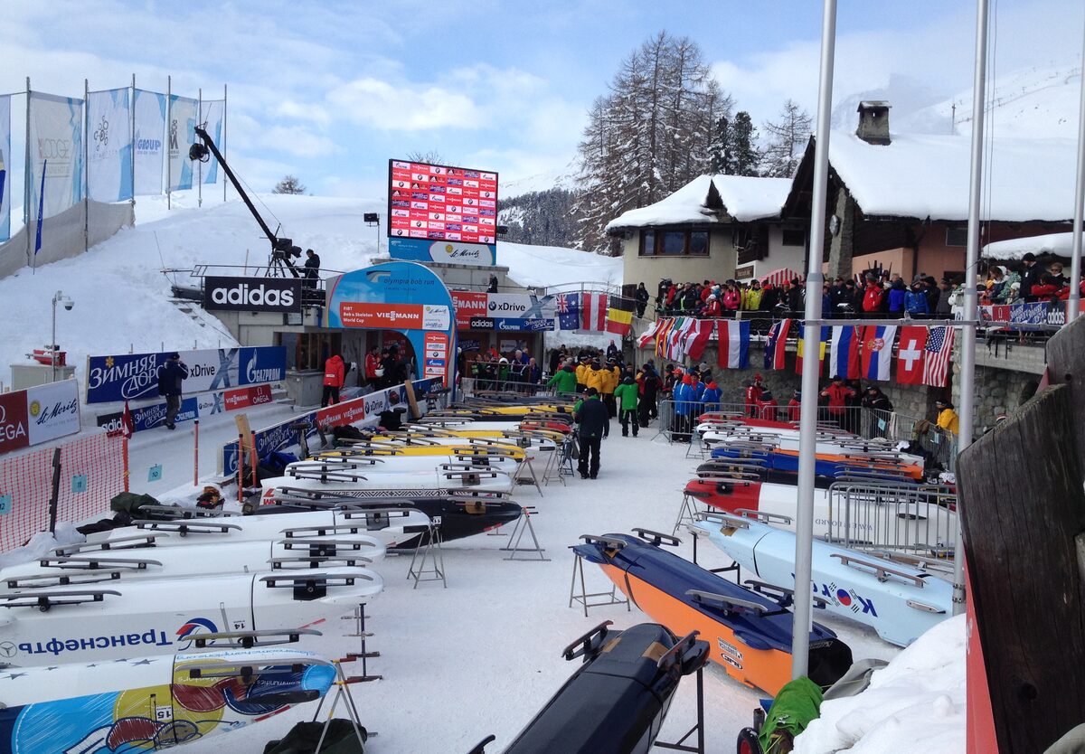 Bobsleds lined up at the start area of the Olympia Bob Run during a World Cup race, with snow on the roofs