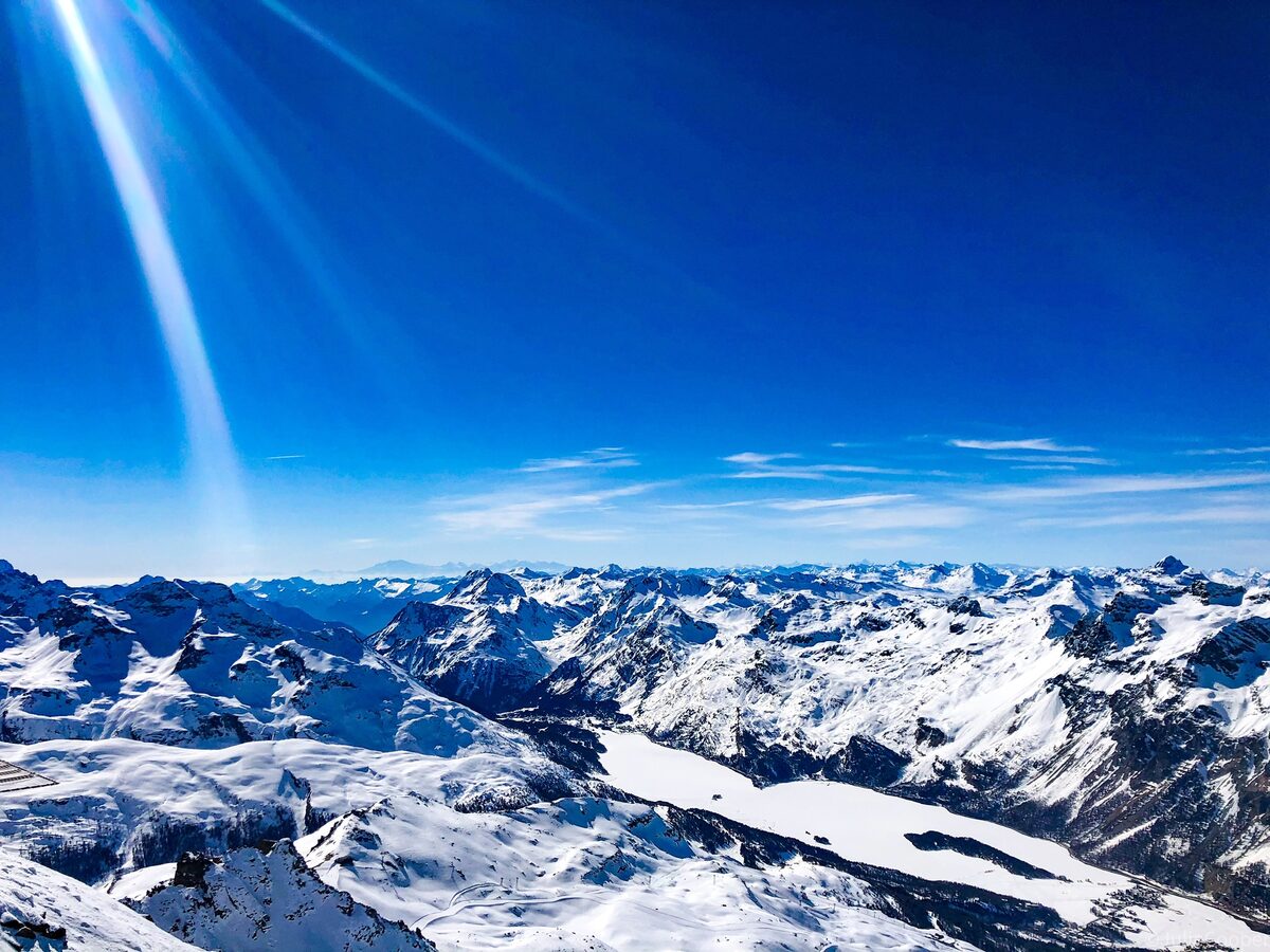 Snow-covered peaks seen from Corvatsch in winter, with the Engadin lakes below