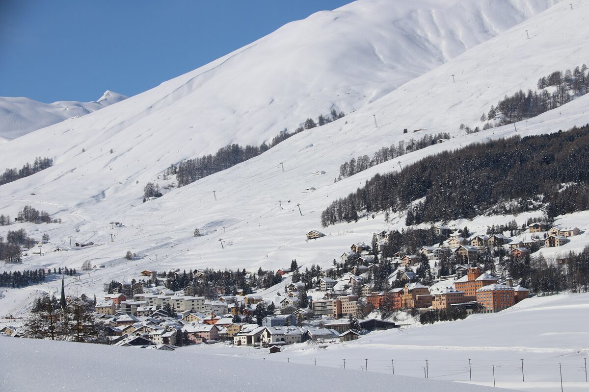 The village of Zuoz in deep snow, with ski slopes climbing the hillside above