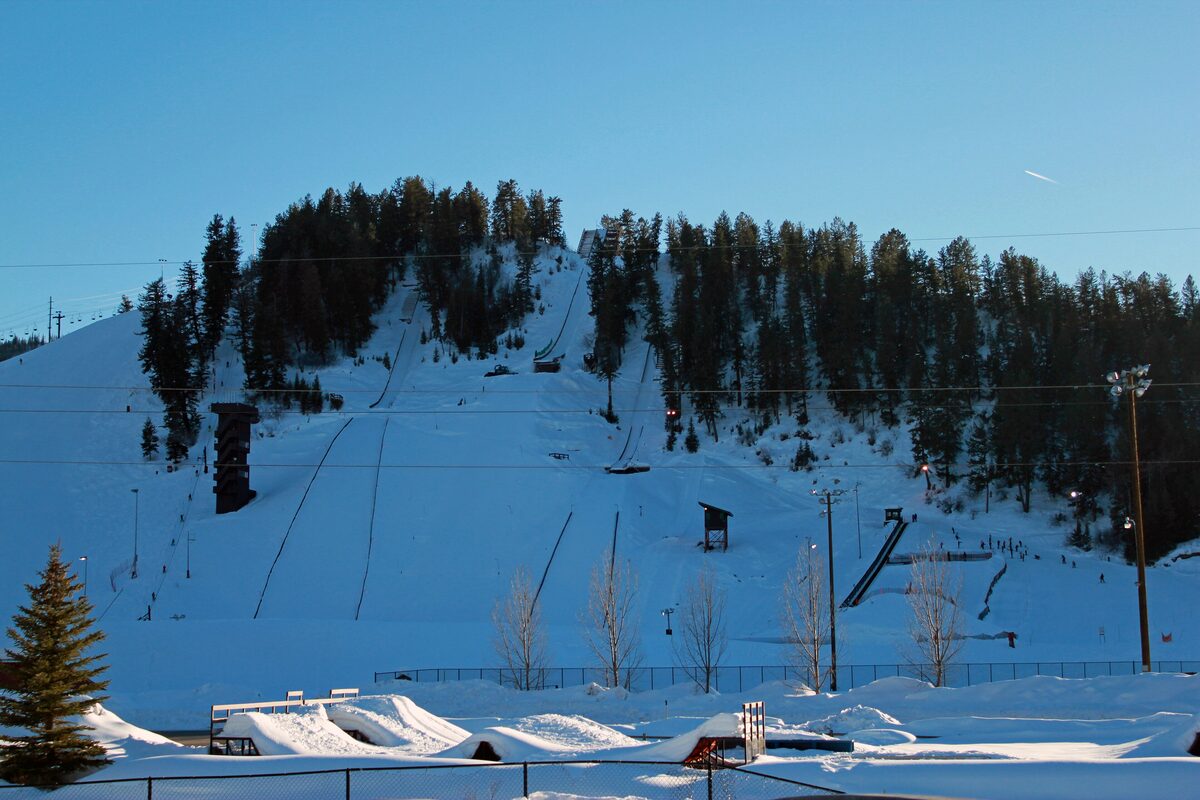 Snow-covered Howelsen Hill with ski jumps and a terrain park below