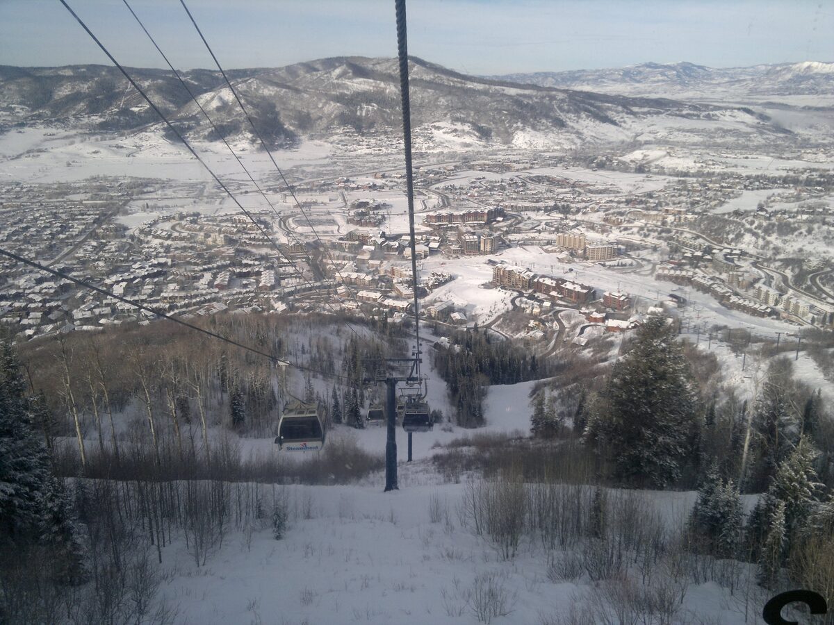 Looking down from a gondola cabin over the town and snowy slopes
