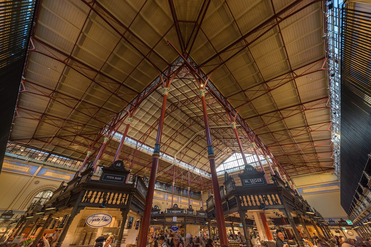The tall iron roof and wooden stalls inside Östermalms saluhall, Stockholm's 1888 market hall