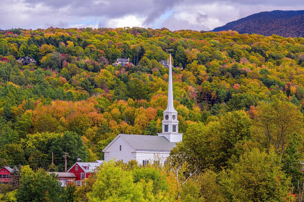 White Stowe Community Church steeple above autumn forest hills
