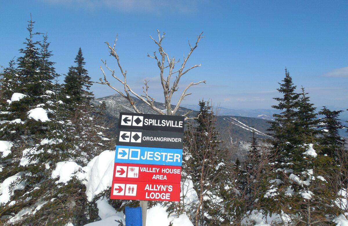 Ski trail signs among snowy spruce trees at Sugarbush