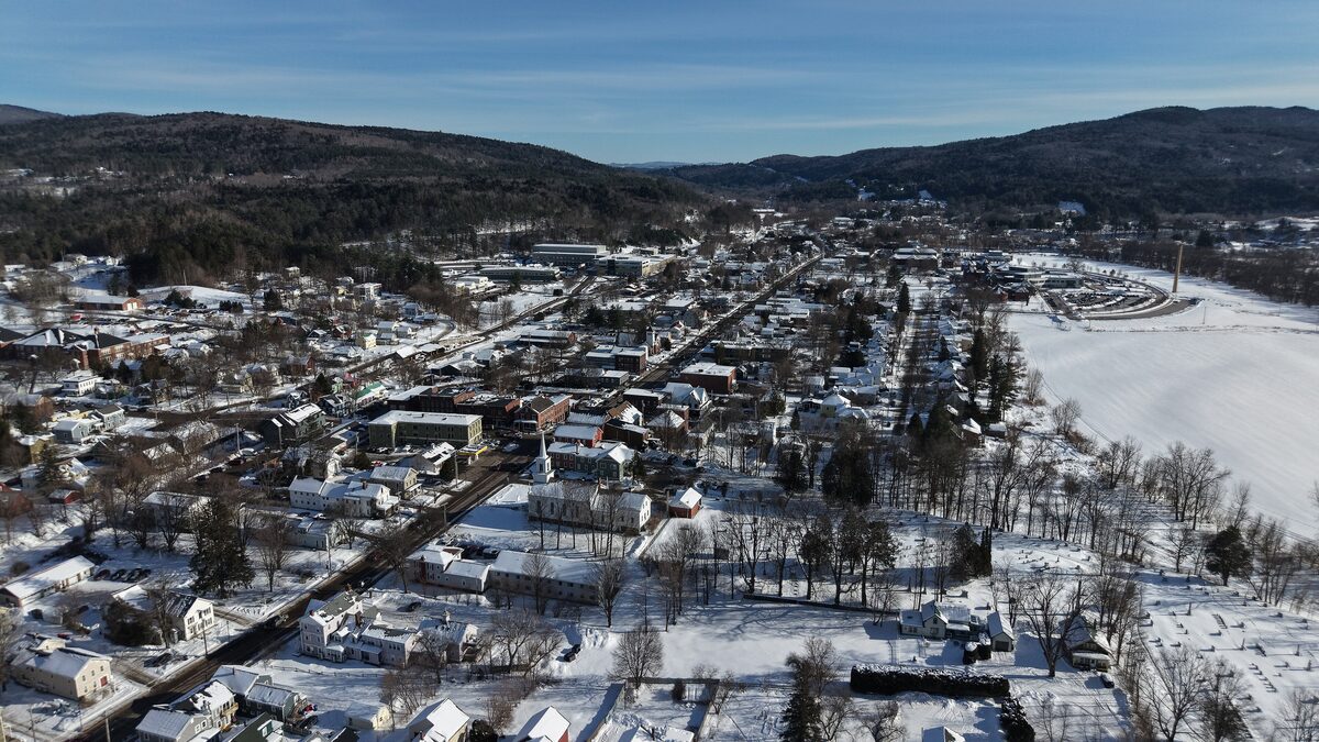Aerial view of snowy Waterbury, Vermont, with hills beyond