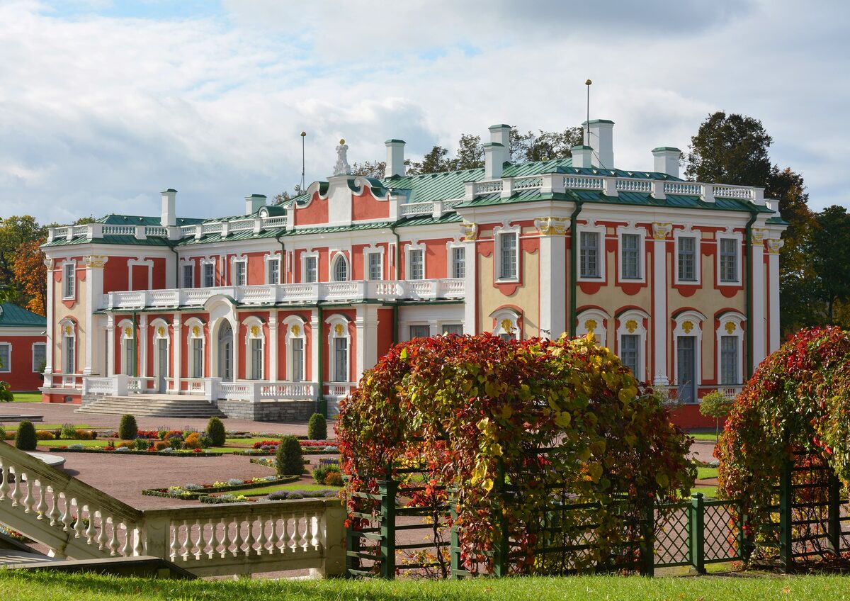 The pink and white baroque Kadriorg Palace behind autumn vines and a stone balustrade