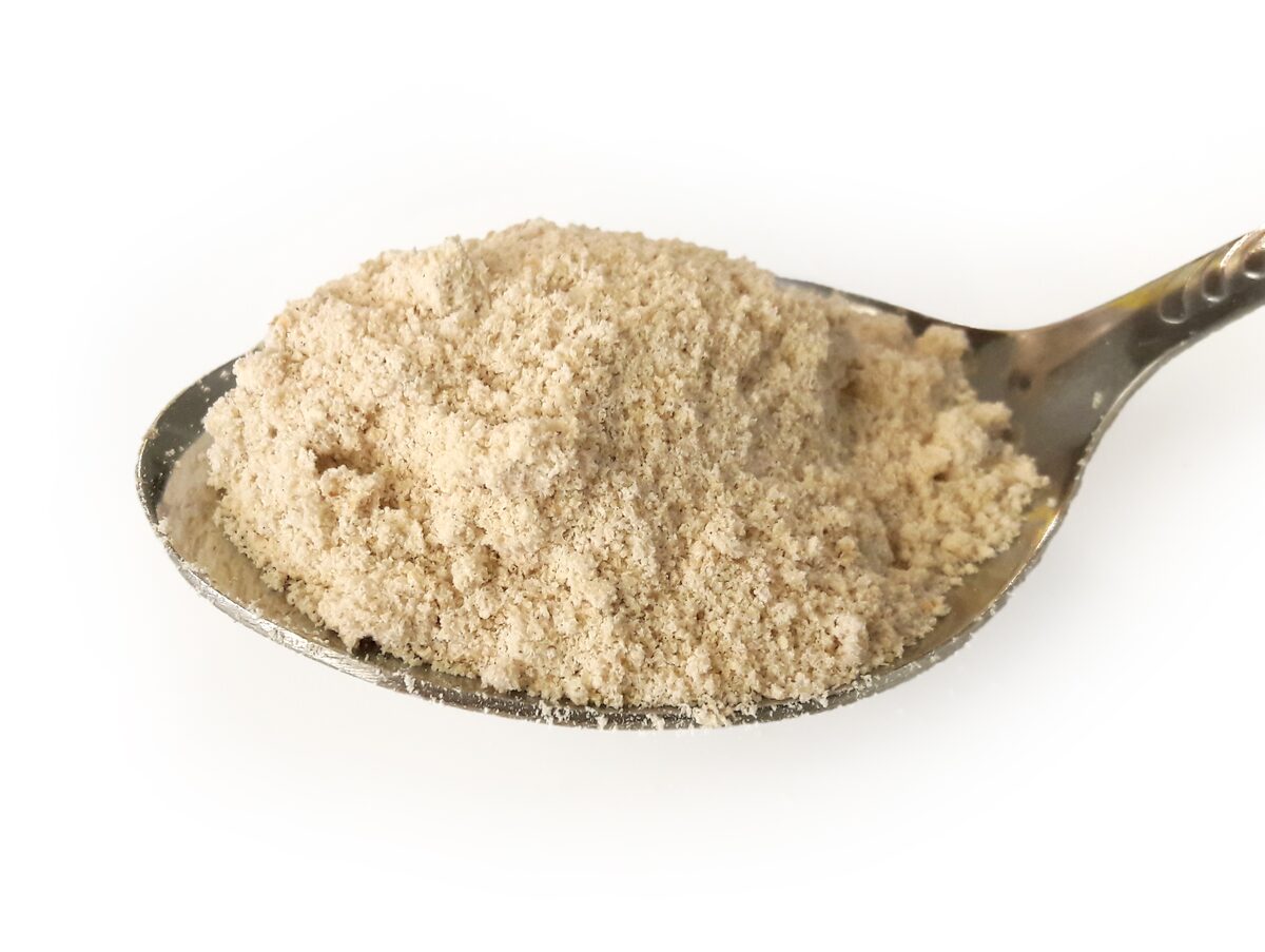 A spoonful of kama, the roasted grain flour, on a white background