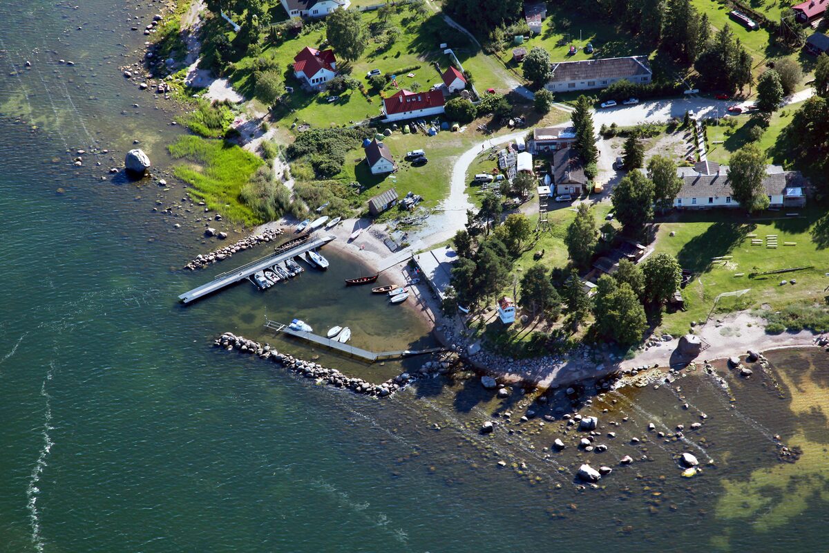 Aerial view of Käsmu harbour, with small wooden houses and a jetty on the rocky shore