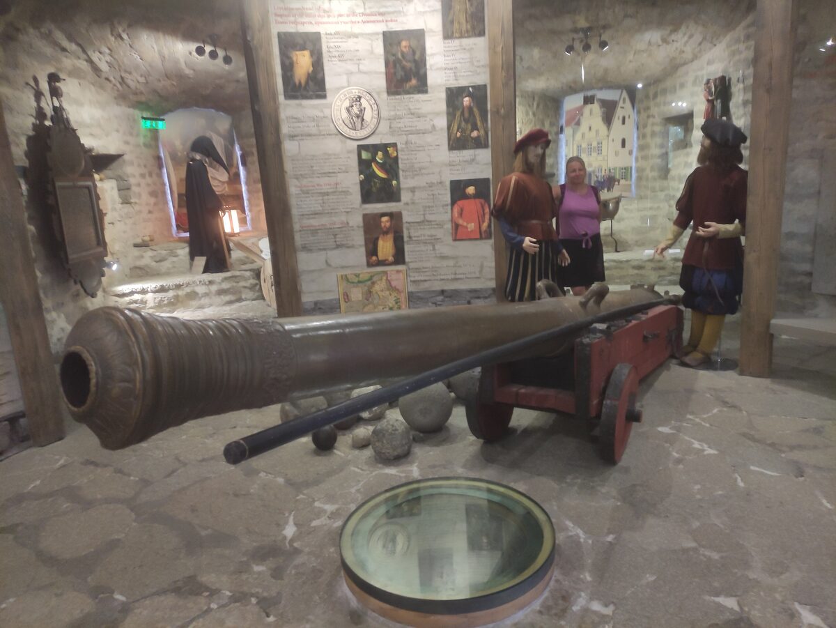 A cannon and figures in costume inside the stone passages of the Kiek in de Kök tower