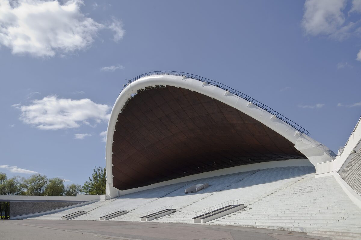 The white arched shell of the Song Festival Grounds stage under a blue sky