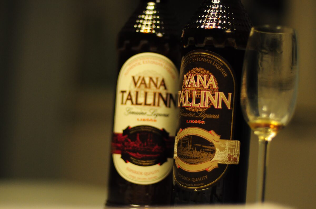 Two dark bottles of Vana Tallinn liqueur beside a small glass