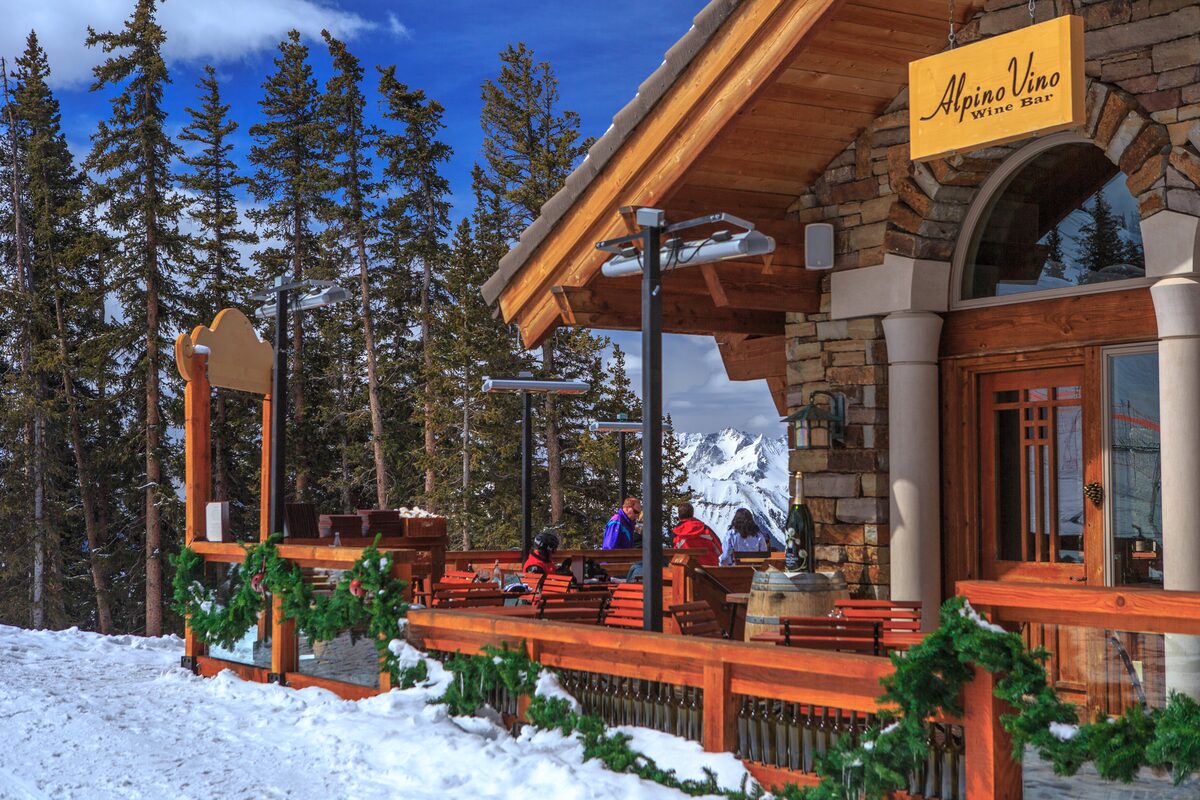 Skiers on the snowy deck of the Alpino Vino wine bar