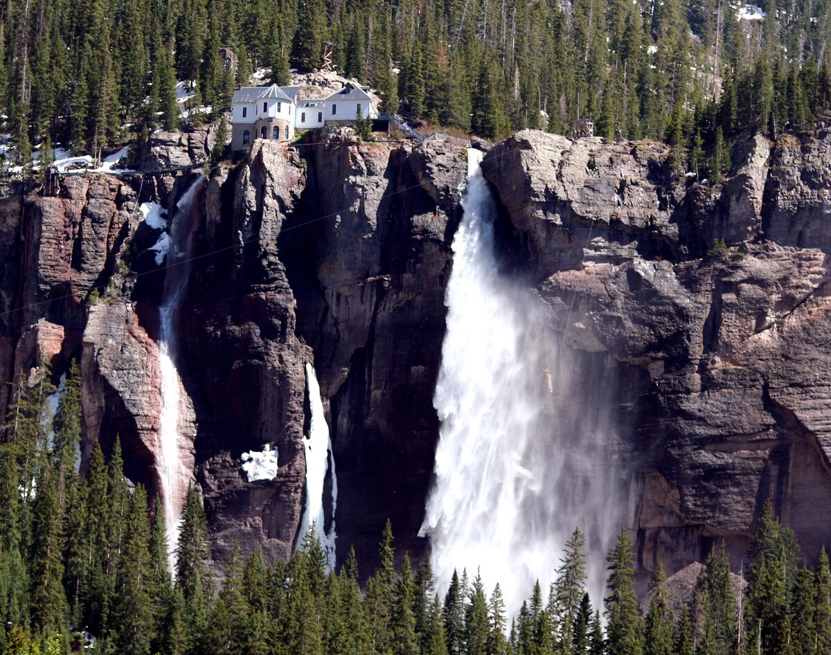 Bridal Veil Falls over a red cliff, with snow and ice streaks beside it