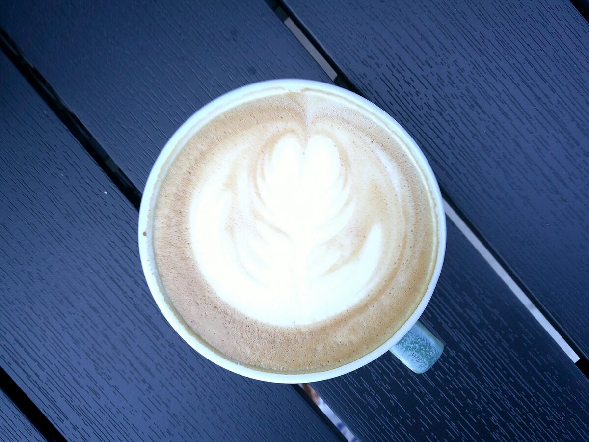A cappuccino with latte art seen from above on a dark table