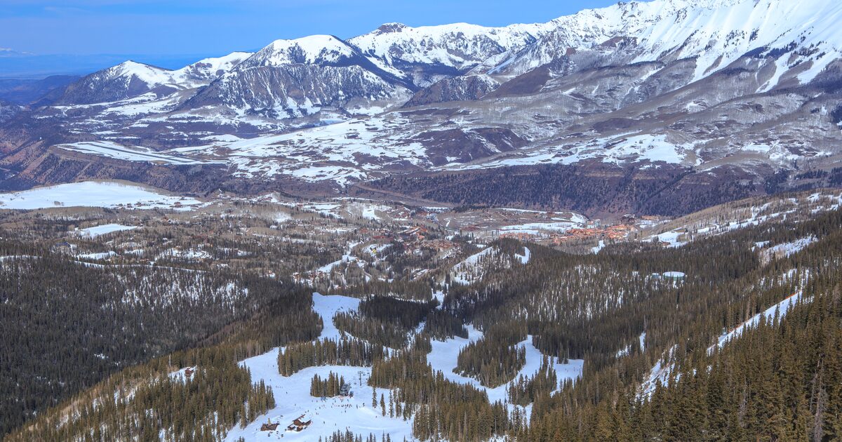 Snowy ski trails through forest below the San Juan peaks near Telluride