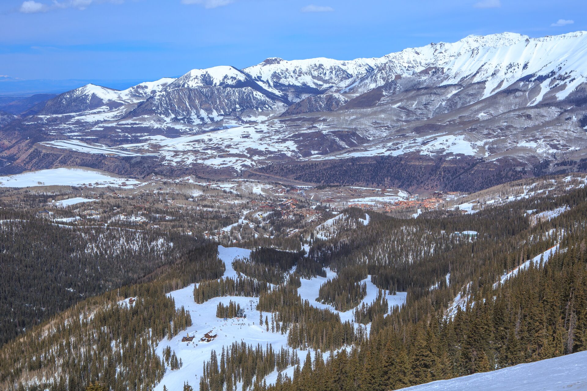 Snowy ski trails through forest below the San Juan peaks near Telluride