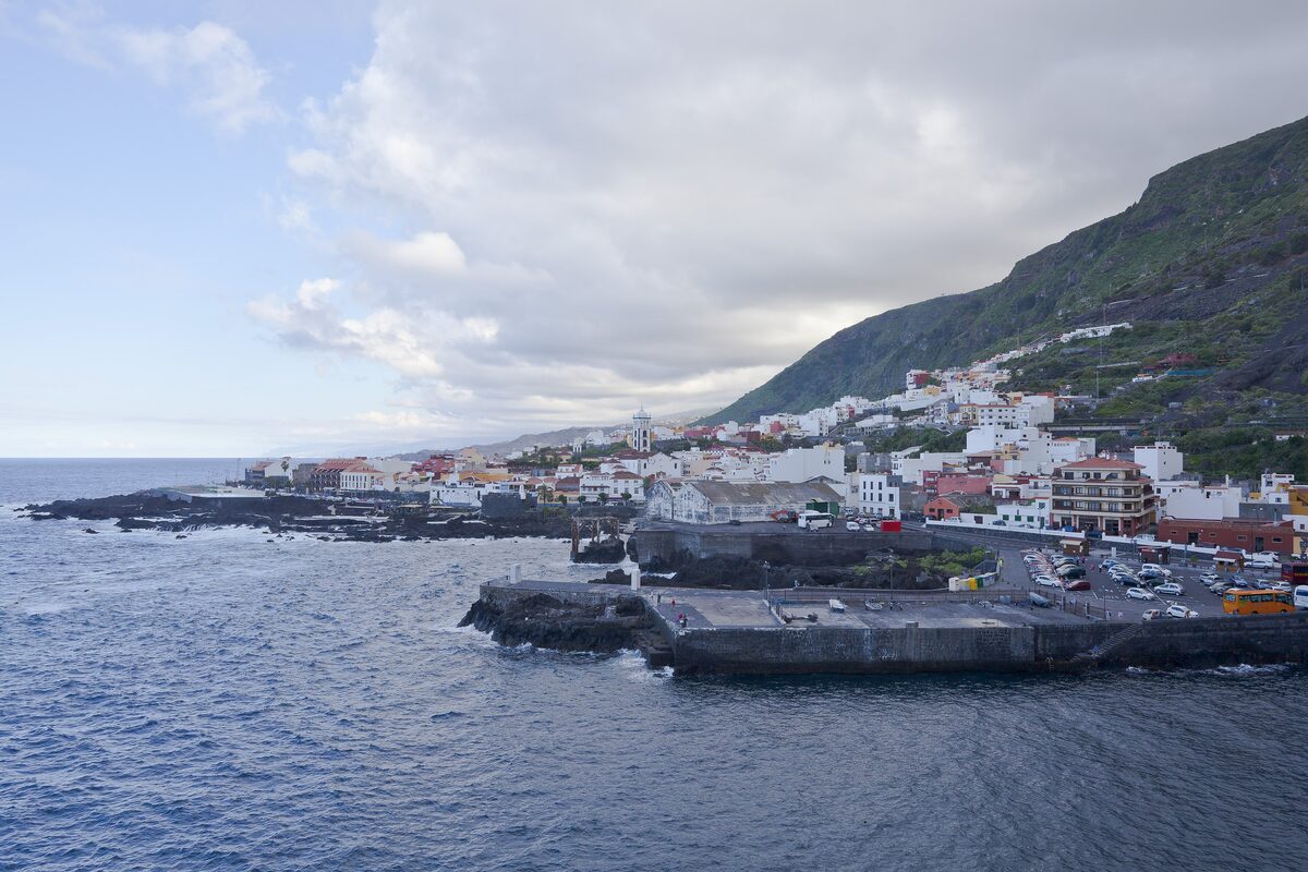 Garachico, its harbor and white houses below a green mountain slope