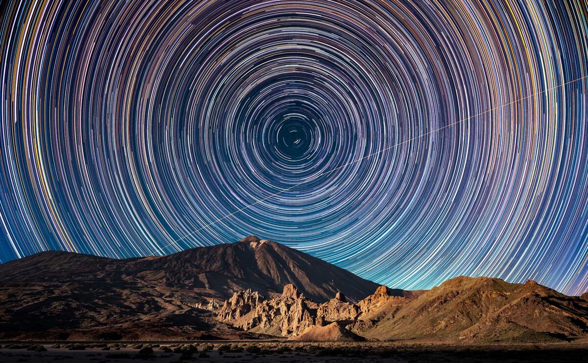 Star trails circling the night sky above Teide and the Roques de García