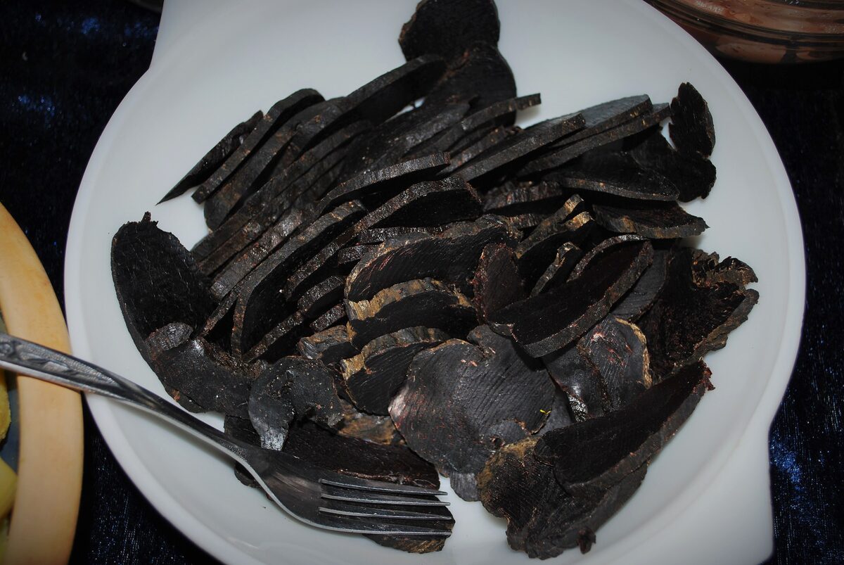 Sliced dried pilot whale meat on a white plate, a traditional Faroese dish