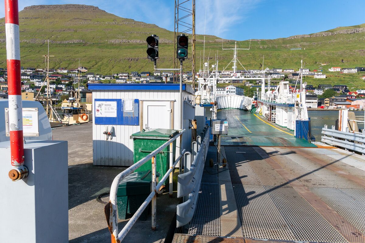 The car ferry at Klaksvík harbor, its ramp open, with the town on the hillside behind