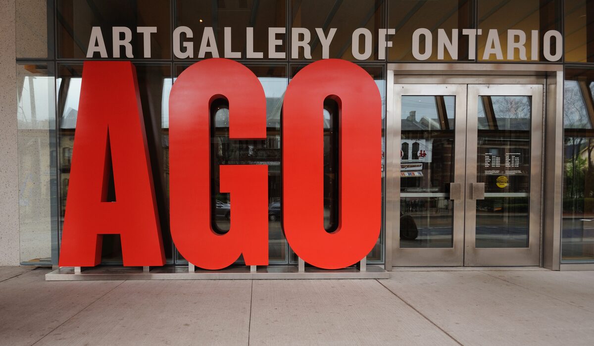 The red AGO letters in front of the glass entrance of the Art Gallery of Ontario