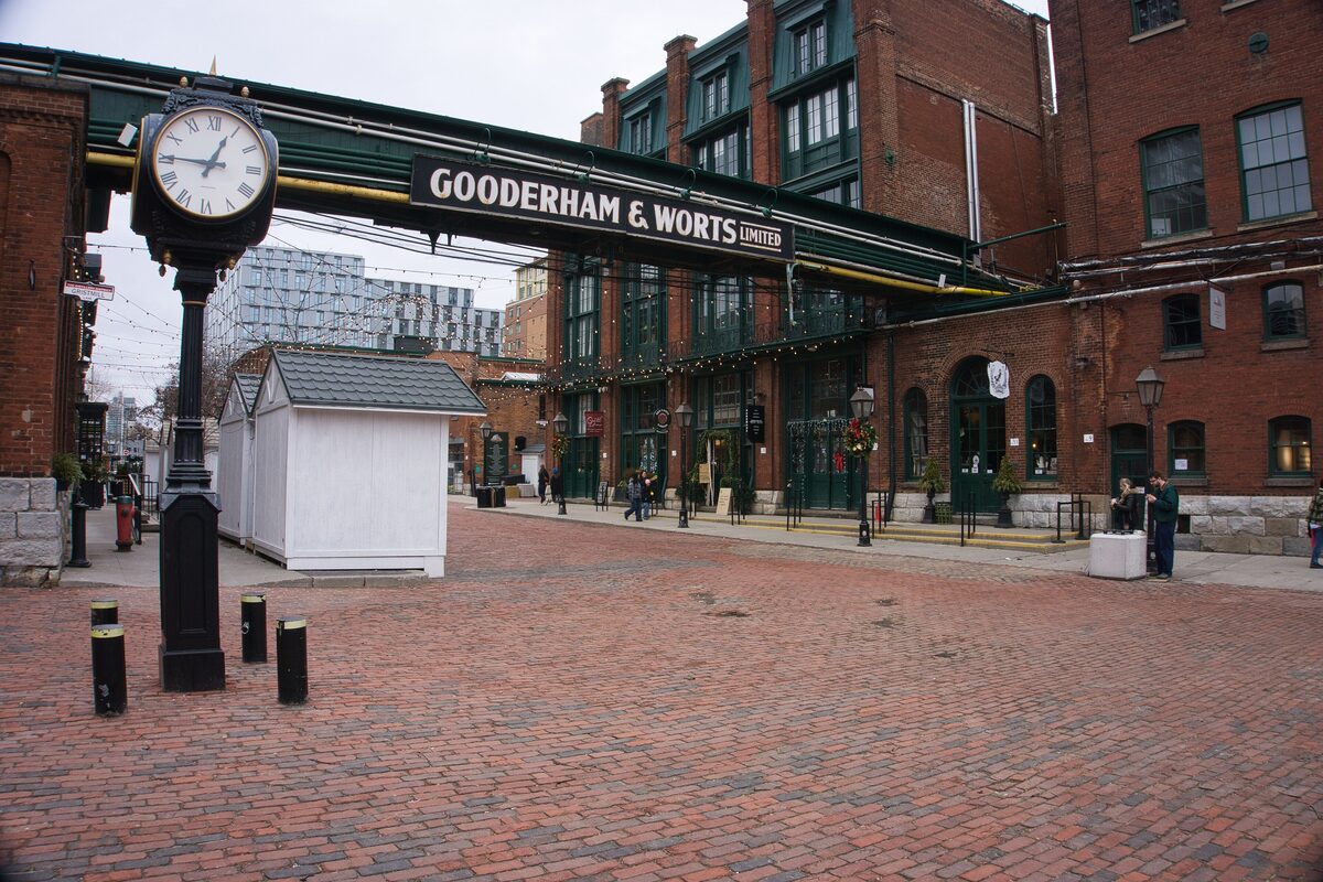 The brick lanes of the Distillery District with the Gooderham and Worts sign, a clock and red-brick factory buildings