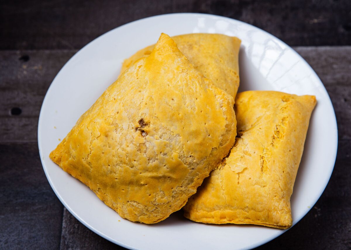 Golden-yellow Jamaican patties on a white plate