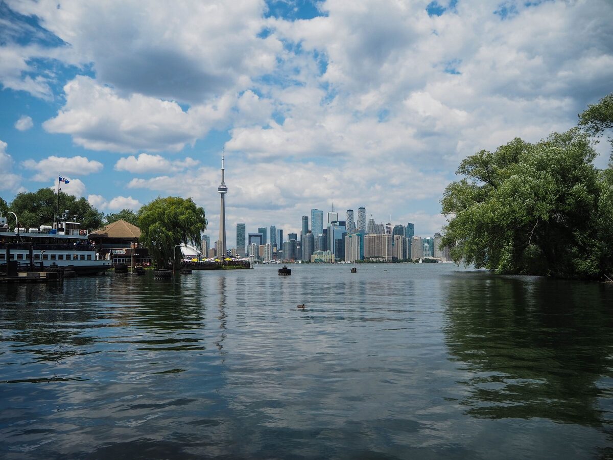 The Toronto skyline and CN Tower seen across the water from the Toronto Islands on a cloudy summer day