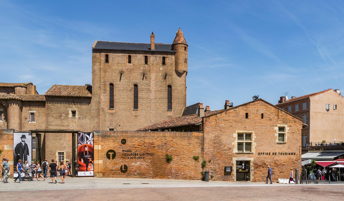 The brick Palais de la Berbie in Albi, with banners at the museum entrance on the square