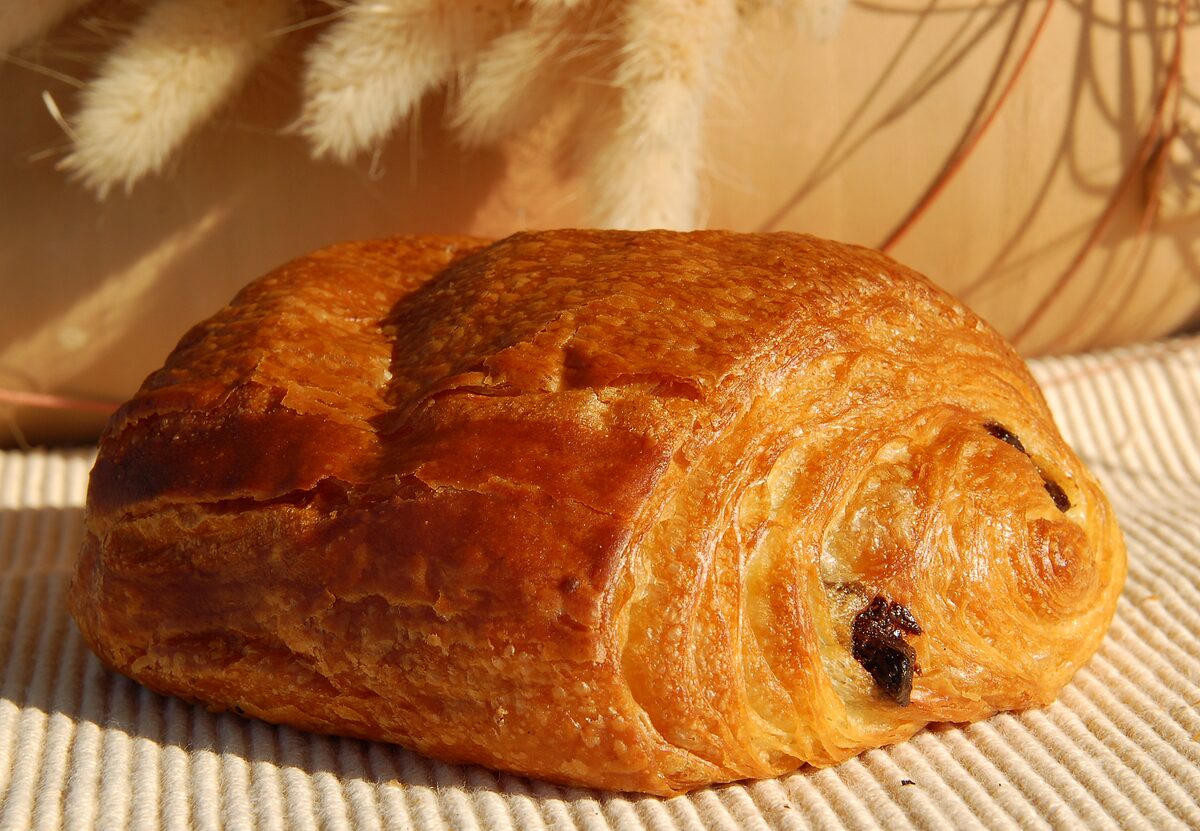 A golden pain au chocolat on a linen cloth