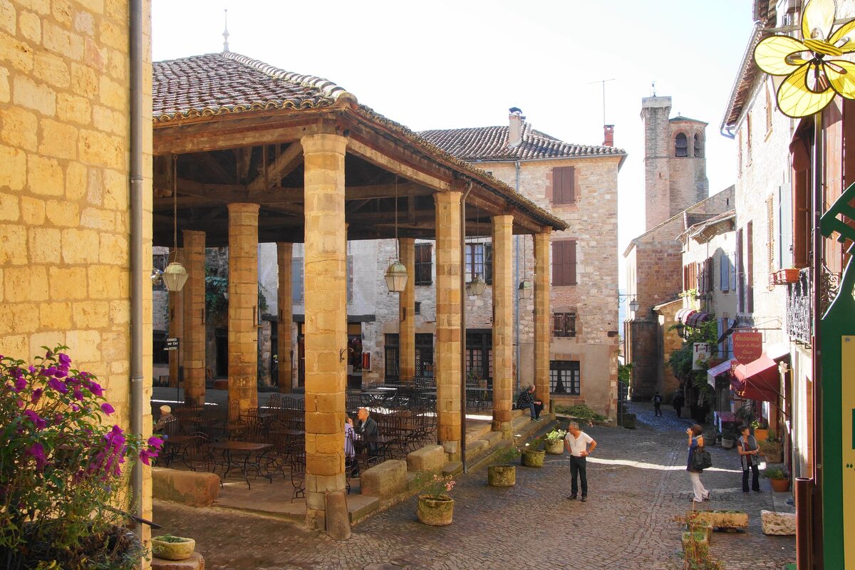A covered market hall with a timber roof on stone pillars in the streets of Cordes-sur-Ciel