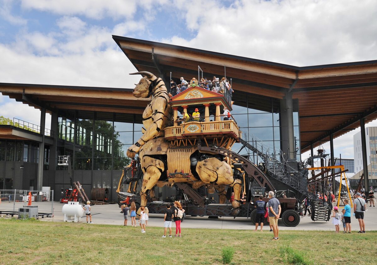 A giant mechanical Minotaur from La Machine in front of its hall in Toulouse, with visitors around it