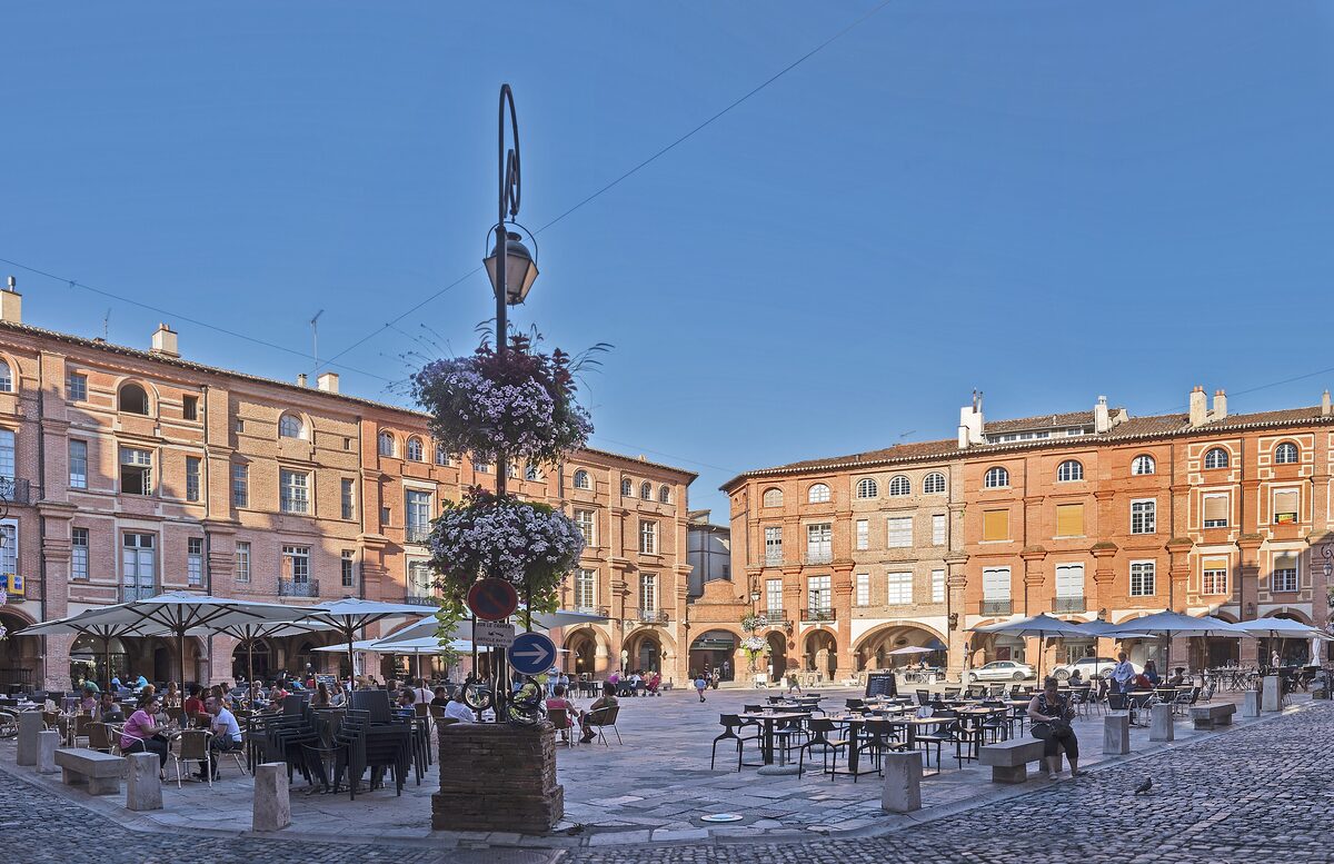 Arcaded brick houses and café terraces around the Place Nationale in Montauban