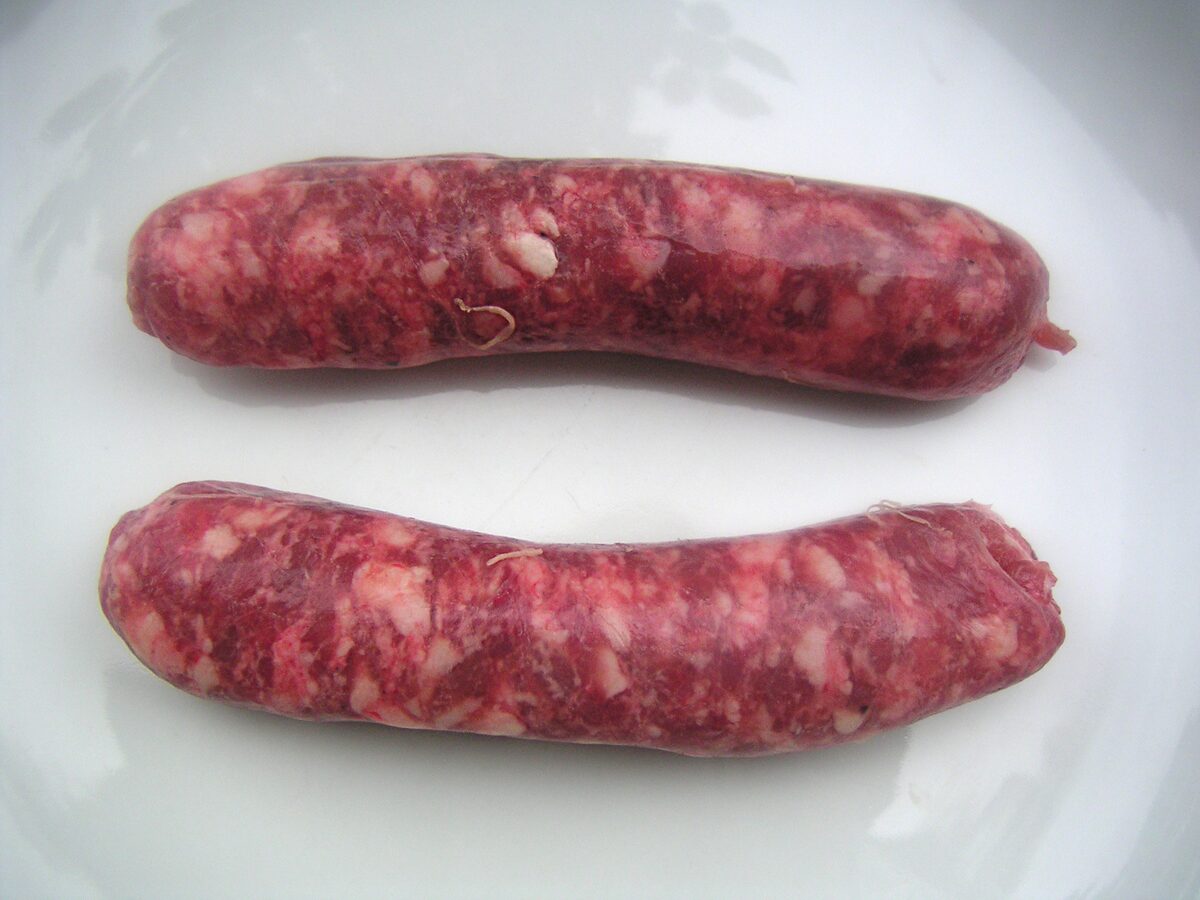 Two raw Toulouse sausages on a white plate