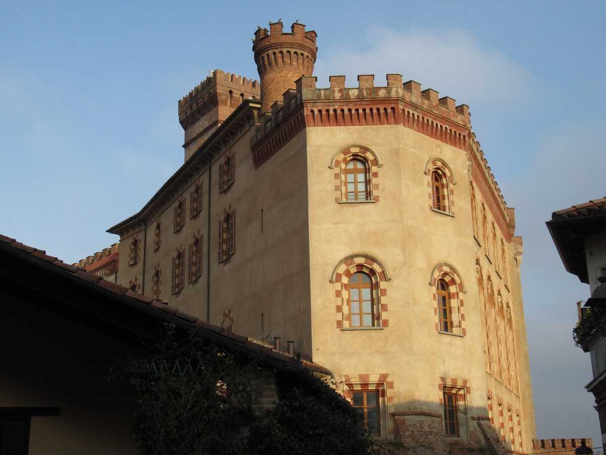 Barolo Castle, ochre walls with crenellated towers and striped window arches