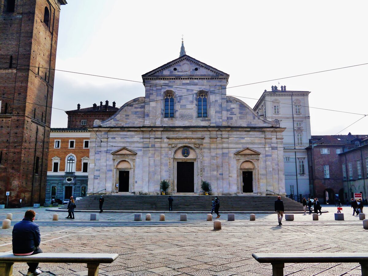 The white Renaissance facade of Turin Cathedral on its square