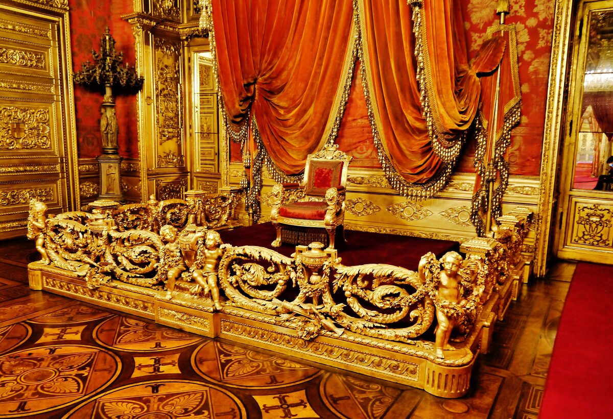 The gilded throne room of the Royal Palace, with red velvet drapes