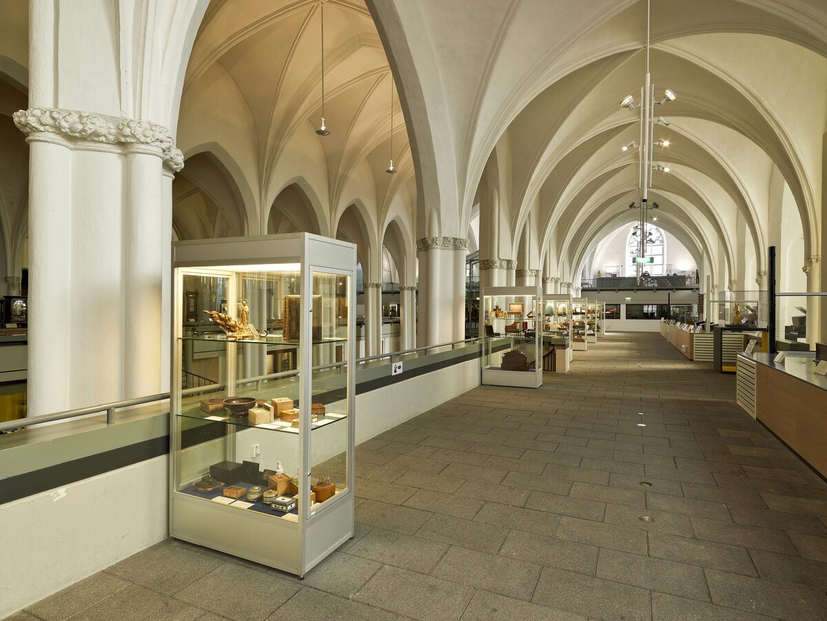 Glass display cases of mechanical instruments under the white Gothic vaults of the Buurkerk, home of Museum Speelklok