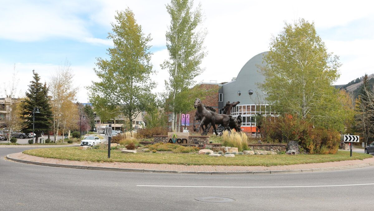 The roundabout in the center of Avon with a bronze horse sculpture, aspens in autumn color and the Avon Performance Pavilion behind