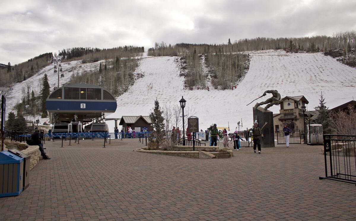 Mountain Plaza at Vail Village with the Gondola One station and snow on the slopes behind it