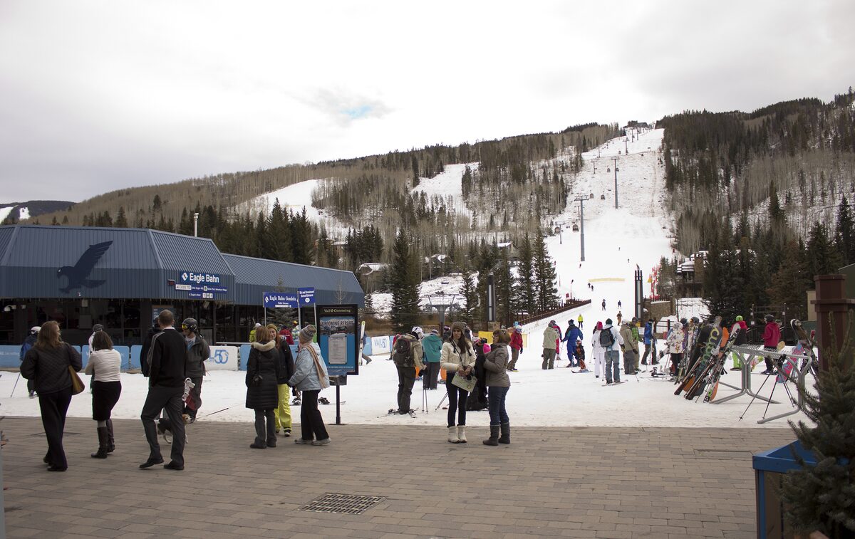 The Lionshead base in snow with the Eagle Bahn gondola station and skiers on the plaza
