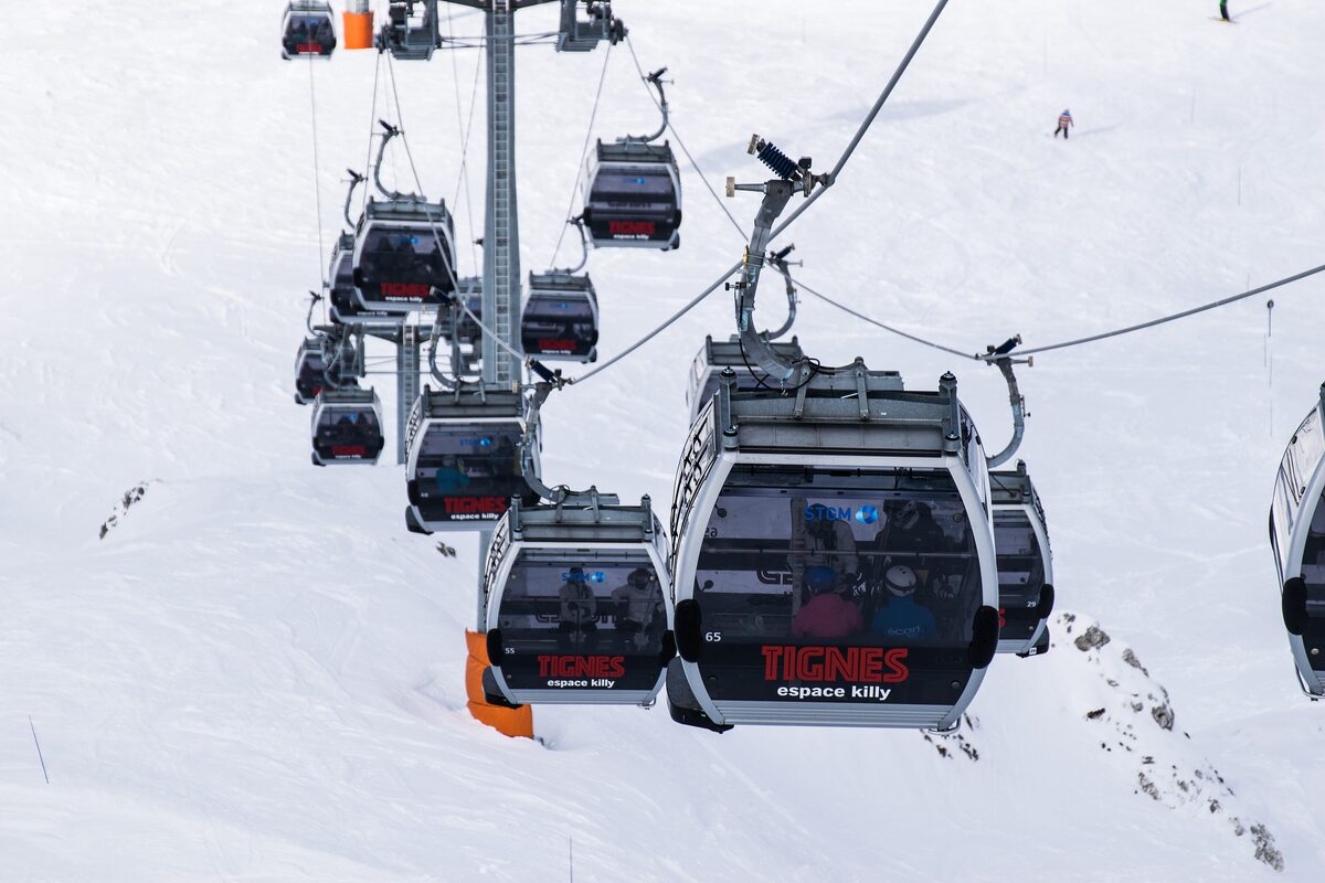 Gondola cabins marked Tignes climbing above the snow on the Espace Killy ski area