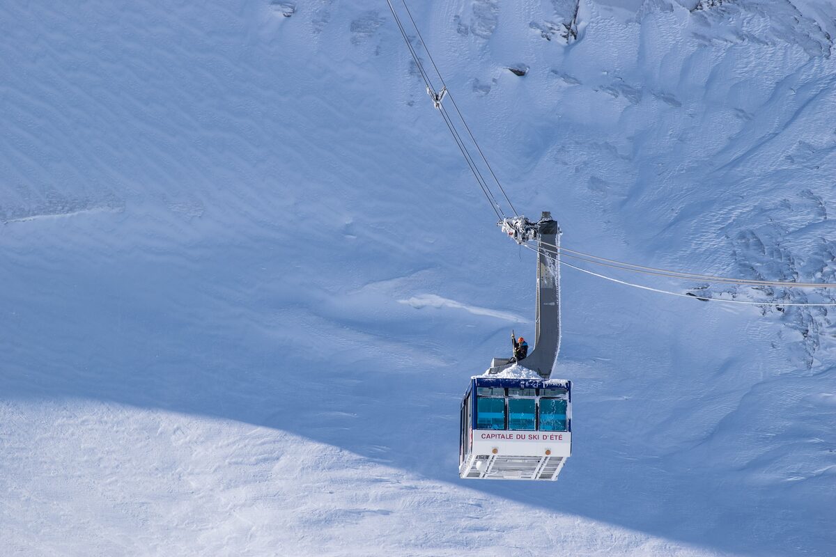 A cable car cabin climbing above the snow on the Grande Motte glacier