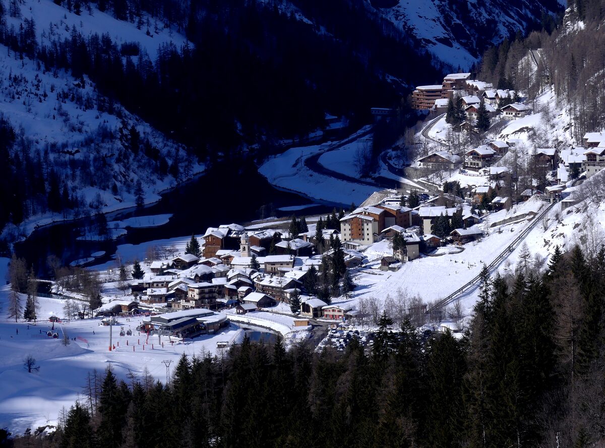 The chalets of Les Brévières under snow, seen from above the Tignes dam