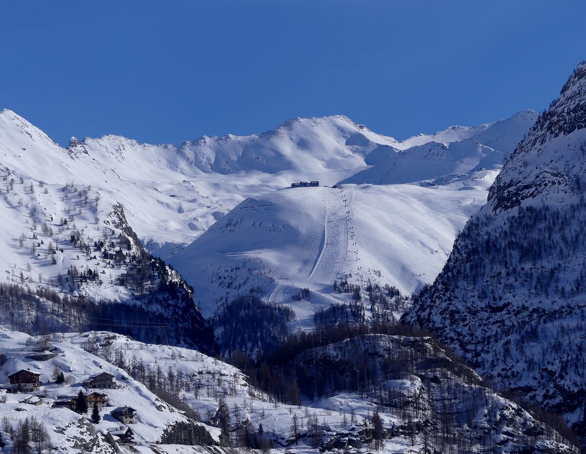 The snowy slopes of Solaise above Val d'Isère with a piste cut down the mountainside, seen from the Tignes dam
