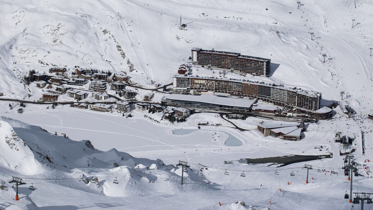 Tignes Le Lac in winter, with a row of big hotel blocks and ski lifts on the snowy slopes above